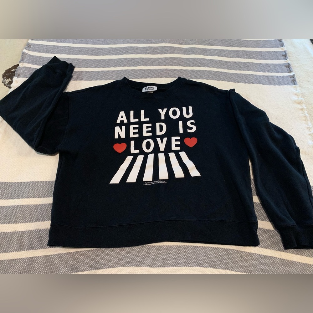 “All You Need Is Love” black crew neck sweatshirt.